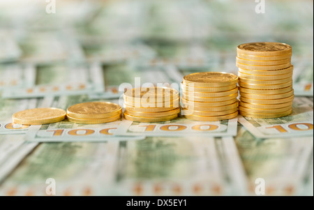 Pila di golden eagle monete in valuta statunitense banconote da cento dollari Foto Stock