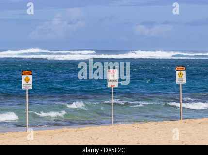 Tre segni di avvertenza su una spiaggia alle Hawaii - non si può nuotare e forti correnti in insidiose acque di inverno Foto Stock