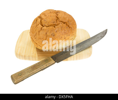 Un piccolo insieme di frumento boule il pane su un legno tagliere con il vecchio coltello da cucina. Foto Stock