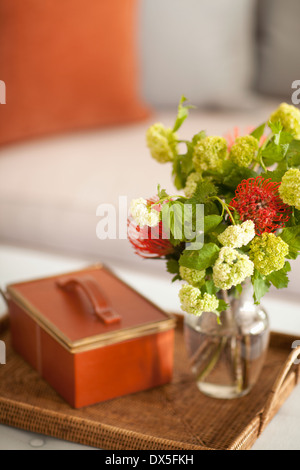 Spider mamme e verde e bianco viburnum mazzo di fiori in vaso sul vassoio con scatola in pelle Foto Stock