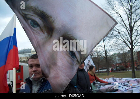 Mosca, Russia. Xviii Mar, 2014. Un uomo tiene le bandiere con la faccia di Vladimir Putin prima di rally dedicata alla adesione Crimea alla Russia sulla Piazza Rossa. Credito: Anna Sergeeva/ZUMAPRESS.com/Alamy Live News Foto Stock