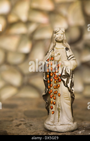 Gesù figurina tenendo i grani del rosario, close up Foto Stock