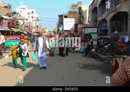 La strada affollata e devoti nella parte anteriore del tempio d'oro di Amritsar. Negozi su entrambi i lati e gente che cammina sulla strada affollata Foto Stock