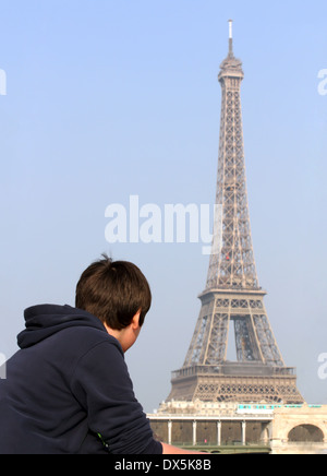 Ragazzo che guarda alla Torre Eiffel a Parigi, Francia Foto Stock