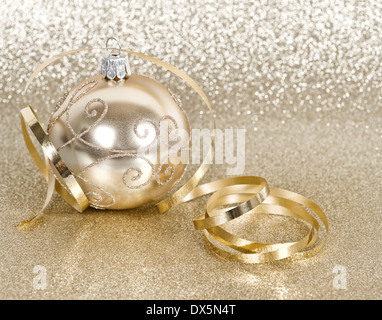 Golden palla di Natale con streamer su golden sfondo lucido Foto Stock