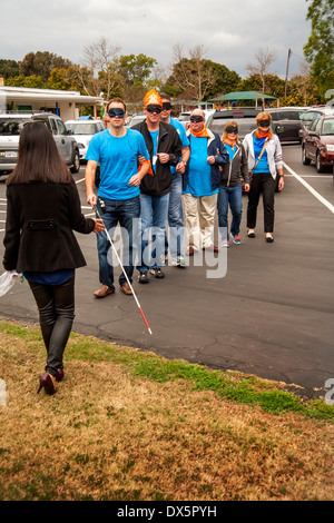 I visitatori di una scuola per ciechi di Tustin, CA, sono gli occhi bendati per consentire loro di fare esperienza sightlessness come imparano ad usare un bastone bianco per camminare in un parcheggio. Foto Stock