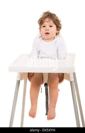 Stupiti toddler boy diritte in piedi nel seggiolone isolati su sfondo bianco Foto Stock