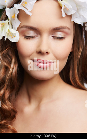 Ritratto di una giovane donna perfetta con i capelli decorato con fiori e gli occhi chiusi Foto Stock