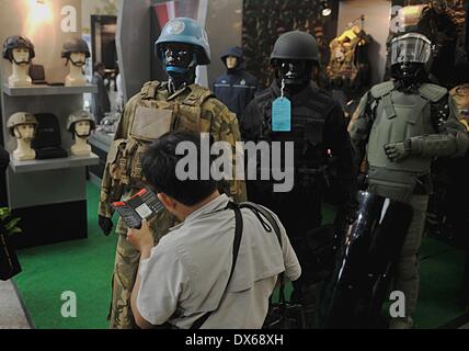 Jakarta, Indonesia. Xix Mar, 2014. Un visitatore guarda uniformi militari visualizzati su una esposizione durante il Jakarta difesa internazionale il dialogo in Jakarta, Indonesia, Marzo 19, 2014. Indonesia aperta mercoledì il quarto anno il dialogo informale tra i funzionari della difesa da parte di diversi paesi, prevede di rafforzare la cooperazione in materia di sicurezza marittima e di stabilità. © Agung Kuncahya B./Xinhua/Alamy Live News Foto Stock