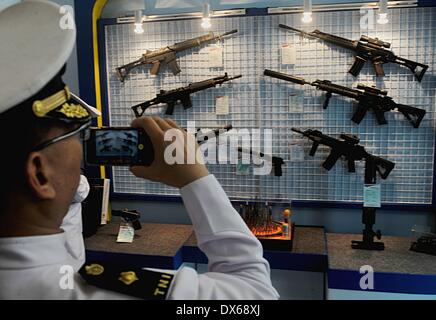 Jakarta, Indonesia. Xix Mar, 2014. Un visitatore prende foto di pistole visualizzati su una esposizione durante il Jakarta difesa internazionale il dialogo in Jakarta, Indonesia, Marzo 19, 2014. Indonesia aperta mercoledì il quarto anno il dialogo informale tra i funzionari della difesa da parte di diversi paesi, prevede di rafforzare la cooperazione in materia di sicurezza marittima e di stabilità. © Agung Kuncahya B./Xinhua/Alamy Live News Foto Stock