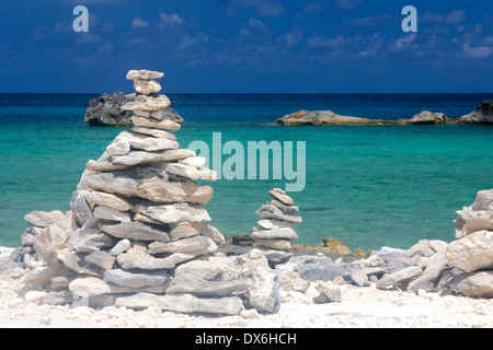 Torre di rocce impilate su una spiaggia caraibica in Bahamas. Foto Stock