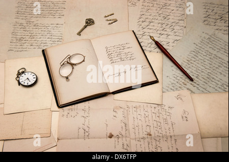 Accessori vintage e libro aperto sopra il vecchio lettere e cartoline. sfondo nostalgico Foto Stock