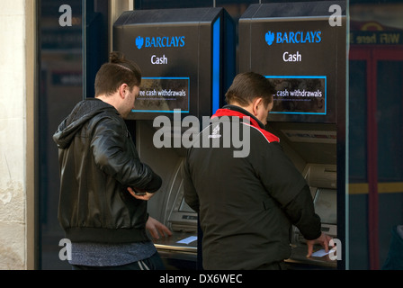 I clienti che utilizzano la Barclays Bank bancomat per il prelievo di contanti, Kingston, Surrey, Regno Unito. Foto Stock