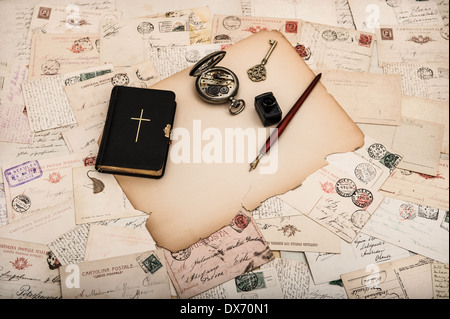 Nero libro della Bibbia con vecchie cartoline e carte. accessori vintage Foto Stock