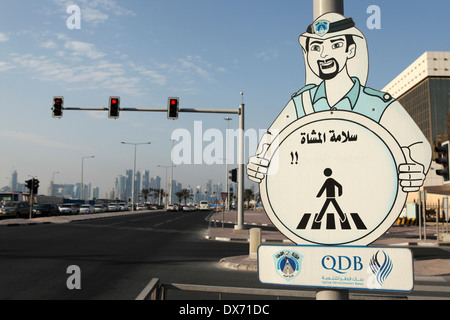 Un segno sollecita attenzione mentre si attraversa la strada a Doha, in Qatar. Foto Stock