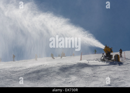 Irrorazione di innevamento artificiale neve sulle piste per sciatori in montagna Foto Stock