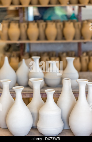 Ripiani con stoviglie in ceramica nel laboratorio di ceramica Foto Stock