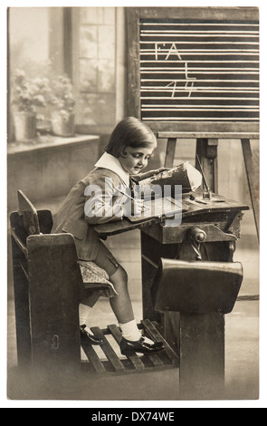 Vintage seppia ritratto di una prima scuola livellatrice ragazza in aula. nostalgico foto Foto Stock