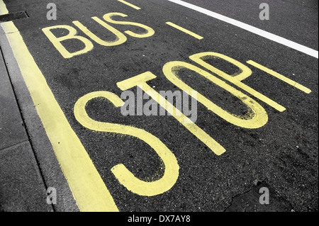 Fermata bus segno con vernice gialla su asfalto Foto Stock