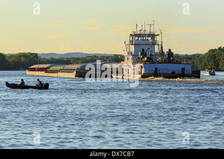 I pescatori passano dietro chiatte granella sul fiume Mississippi su Minnesota Wisconsin confine. Foto Stock