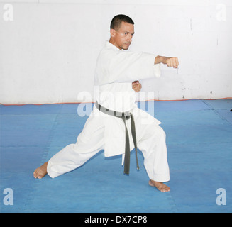 La cintura nera uomo in kimono durante il training karate kata esercizi in palestra Foto Stock