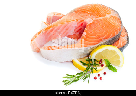 Bistecca di salmone decorate con basilico, limone e rosmarino su uno sfondo bianco. Foto Stock