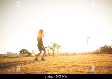 Un giovane maschio adatta a fare tai chi al mattino presto sun Foto Stock