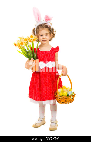 Bellissima ragazza con orecchie di coniglietto cestello di contenimento con uova di Pasqua e narcisi isolati su sfondo bianco Foto Stock