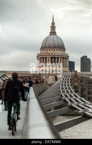 Un ciclista e pedestians sul Millennium Bridge guardando verso San Paolo cathedra,l Londra Foto Stock