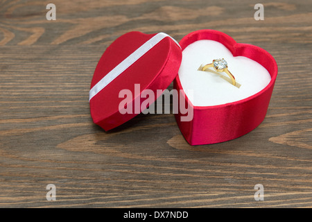 Diamante anello di aggancio in una seta rossa a forma di cuore scatola. Foto Stock