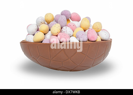 La metà di un cioccolato uovo di pasqua pieno di mini candy rivestita di uova, isolato su uno sfondo bianco. Foto Stock