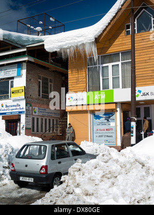 India, Kashmir, Tangmarg bazaar, nevicate su negozi e di Jammu e Kashmir banca bancomat Foto Stock