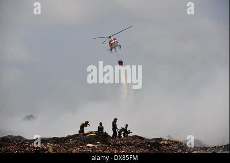 Samut Prakan, Thailandia. 20 Mar, 2014. I vigili del fuoco di mettere fuori un enorme incendio presso un garbage sito di smaltimento in Samut Prakan provincia, Thailandia, 20 marzo 2014. Un incendio ha iniziato a Samut Prakan provincia di Thailandia il 16 marzo e rilasciato il gas tossici nell'aria. Le persone che vivono vicino alla masterizzazione di discarica di rifiuti sono stati costretti a rifugiarsi al di fuori della zona di pericolo. Credito: Rachen Sageamsak/Xinhua/Alamy Live News Foto Stock