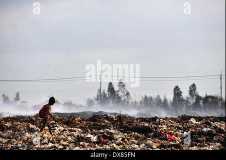 Samut Prakan, Thailandia. 20 Mar, 2014. Un ragazzo cammina come vigili del fuoco di mettere fuori un enorme incendio presso un garbage sito di smaltimento in Samut Prakan provincia, Thailandia, 20 marzo 2014. Un incendio ha iniziato a Samut Prakan provincia di Thailandia il 16 marzo e rilasciato il gas tossici nell'aria. Le persone che vivono vicino alla masterizzazione di discarica di rifiuti sono stati costretti a rifugiarsi al di fuori della zona di pericolo. Credito: Rachen Sageamsak/Xinhua/Alamy Live News Foto Stock