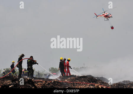 Samut Prakan, Thailandia. 20 Mar, 2014. I vigili del fuoco di mettere fuori un enorme incendio presso un garbage sito di smaltimento in Samut Prakan provincia, Thailandia, 20 marzo 2014. Un incendio ha iniziato a Samut Prakan provincia di Thailandia il 16 marzo e rilasciato il gas tossici nell'aria. Le persone che vivono vicino alla masterizzazione di discarica di rifiuti sono stati costretti a rifugiarsi al di fuori della zona di pericolo. Credito: Rachen Sageamsak/Xinhua/Alamy Live News Foto Stock