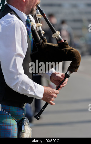 Uomo che indossa Scottish kilt giocando la zampogna, Westminster Bridge, Londra, Inghilterra, Regno Unito. Foto Stock
