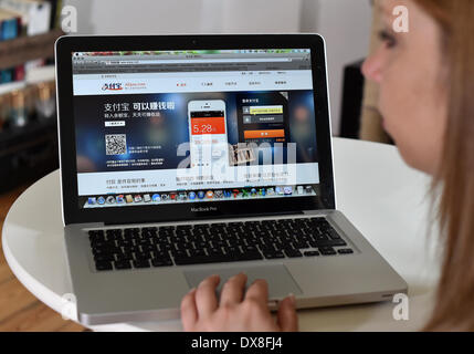 Illustrazione - una giovane donna accede sul suo computer portatile attraverso la pagina web di cinesi online di trasferimento di denaro e di prestatore di servizi di pagamento Alipay a Berlino, Germania, 19 marzo 2014. Foto: Jens Kalaene - Modello rilasciato Foto Stock