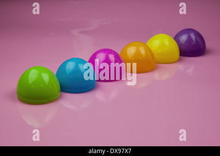 Sei in plastica uovo di pasqua gusci su una lucida sfondo rosa. carino colorato design di Pasqua Foto Stock