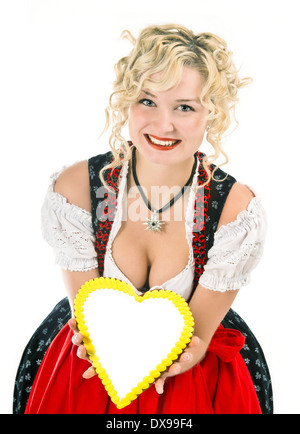 Giovane donna nel tipico abito bavarese dirndl con cuore telaio sagomato per il testo Foto Stock