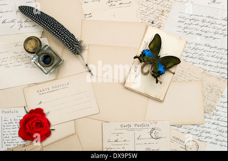 Vecchio lettere, handwritings, cartoline d'epoca e antichi giù penna. nostalgico sfondo sentimentale con farfalla e ro rosso Foto Stock