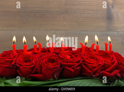 Rose rosse e candele accese facendo ti amo. floreale. messa a fuoco selettiva Foto Stock