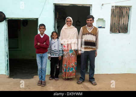 India, Uttar Pradesh, Agra, famiglia che pone al di fuori della loro casa di villaggio Foto Stock