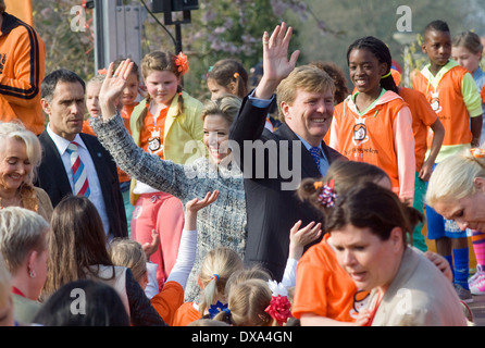 Altezza Reale Regina Maxima e Re Willem Alexander sventolare dopo che hanno appena aperto il 'koningsspelen' su una scuola Foto Stock