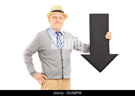 Sorridente uomo senior tenendo una grande freccia nera rivolta verso il basso Foto Stock