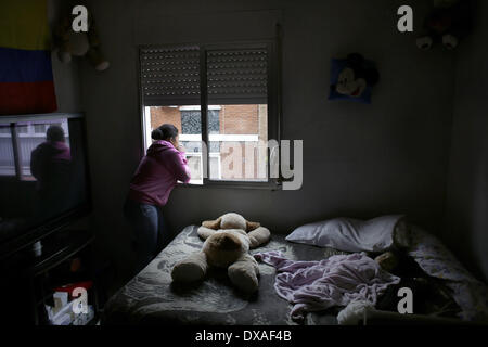 Madrid, Spagna. Xxi Mar, 2014. 22 enne Liseth Saavedra Carranza guarda attraverso la finestra mentre 11 mese vecchio Daniela Chasi Saavedra dorme, come la sua famiglia attendere la commissione giudiziaria e delle forze di polizia di arrivare per strappare loro, in Spagna a Madrid, venerdì 21 marzo, 2014. Daniela vive con sua sorella, i suoi genitori ed i due zii e nonni. Il Chasi Sanguna famiglia, originariamente da Ecuador, acquistato un euro 259.000 (US$ 357,453) appartamento da prendere un mutuo con banca Bankia in 2004, ma hanno cessato di effettuare dei pagamenti dopo Daniela zii perso i loro posti di lavoro nel settore della costruzione in Foto Stock