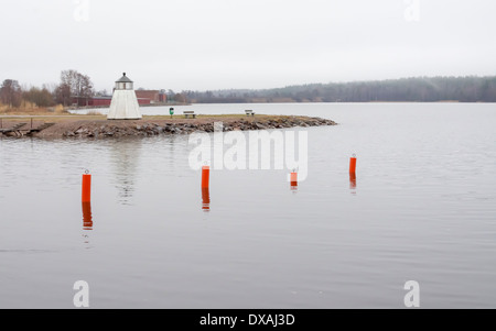 Faro e quattro gavitelli rossi nella piccola città di Dalsland Åmål Svezia in marzo. Foto Stock