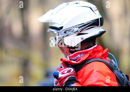 Un uomo strapping un casco durante le prove di un concorso in bicicletta. Foto Stock