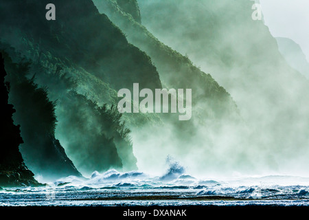 Pomeriggio lungo la costa di Na Pali. Le onde invernali, pesante su questa parte della sponda settentrionale di Kauai, pound le scogliere. Foto Stock