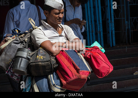 Dabbawala portando il pranzo Dabbas (ristorante Tiffin box) per la consegna ai clienti al di fuori di Churchgate stazione ferroviaria in Mumbai, India Foto Stock