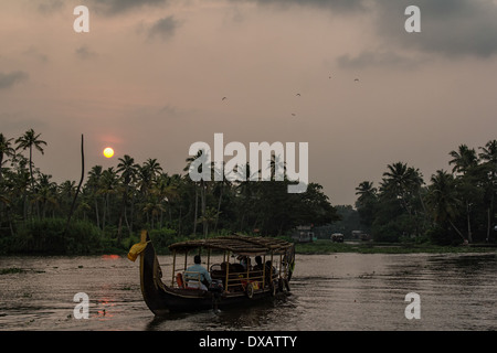 Battello per il trasporto di passeggeri sul fiume in Alleppey Backwaters al tramonto in Kerala, India Foto Stock